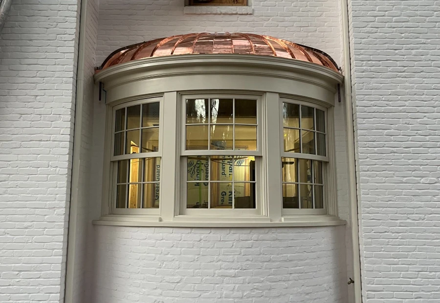 Curved copper bay assembled through coordinated framing, substrate, and finished metal detailing.