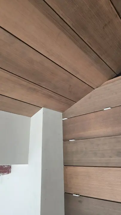 Close construction view of horizontal wood wall boards meeting a matching paneled ceiling.
