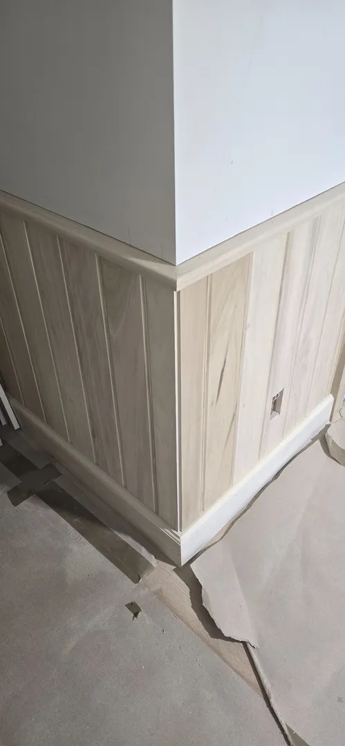 White oak stair wainscot and cap fitted along a descending stair.