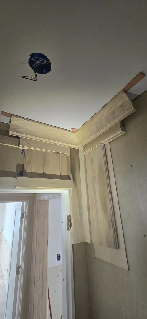 White oak paneling fitted beneath a curved ceiling cove.
