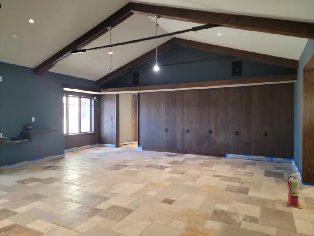 Completed room with full-height wood paneling, exposed roof structure, and integrated lighting.