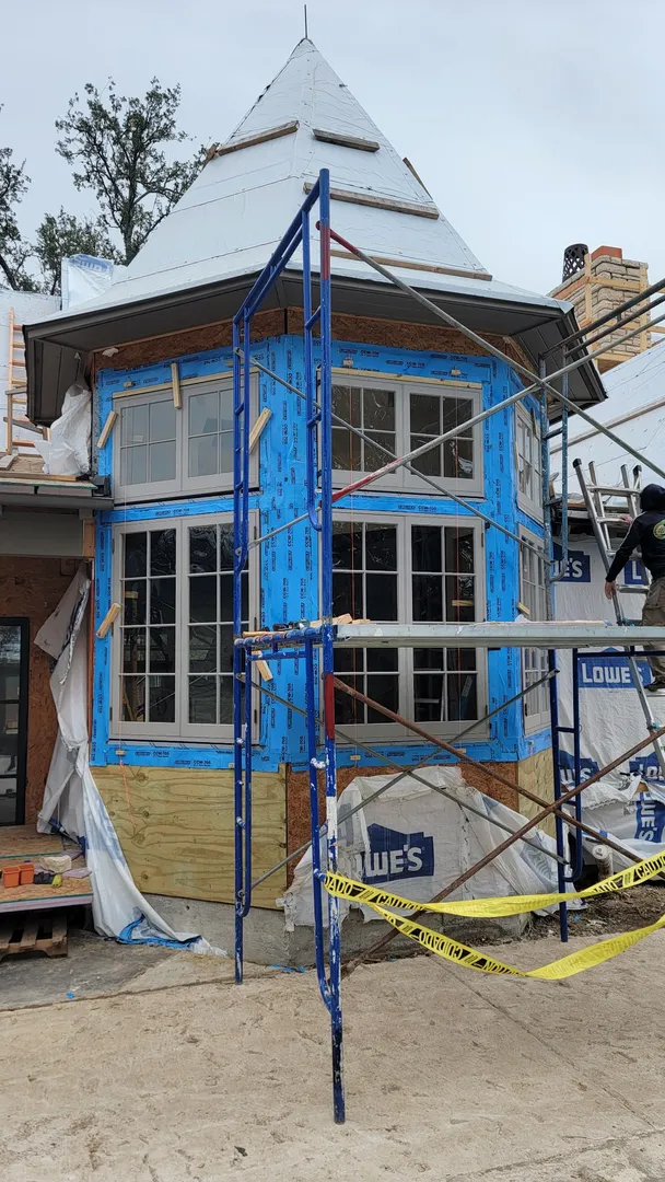 Two-story curved window assembly during exterior installation.