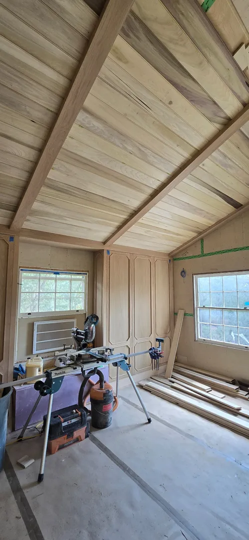 Wide view of the curved white oak ceiling and paneled room during installation.